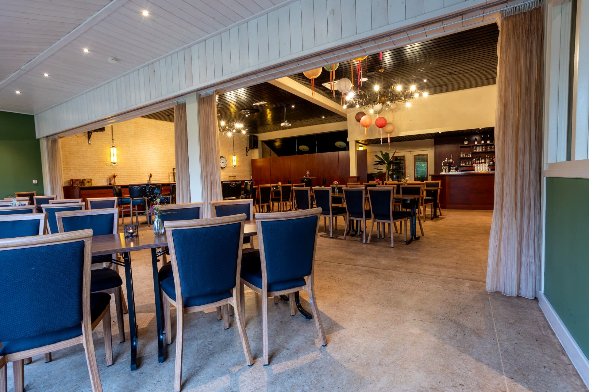 Overzicht van de grote feestzaal van D' Olde Skoele in Rouveen met tafels, stoelen en houten bar
