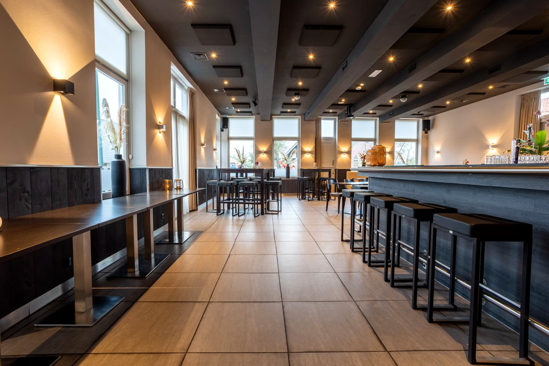 Borrelzaal van D' Olde Skoele in Rouveen met statafels, barkrukken en lange bar