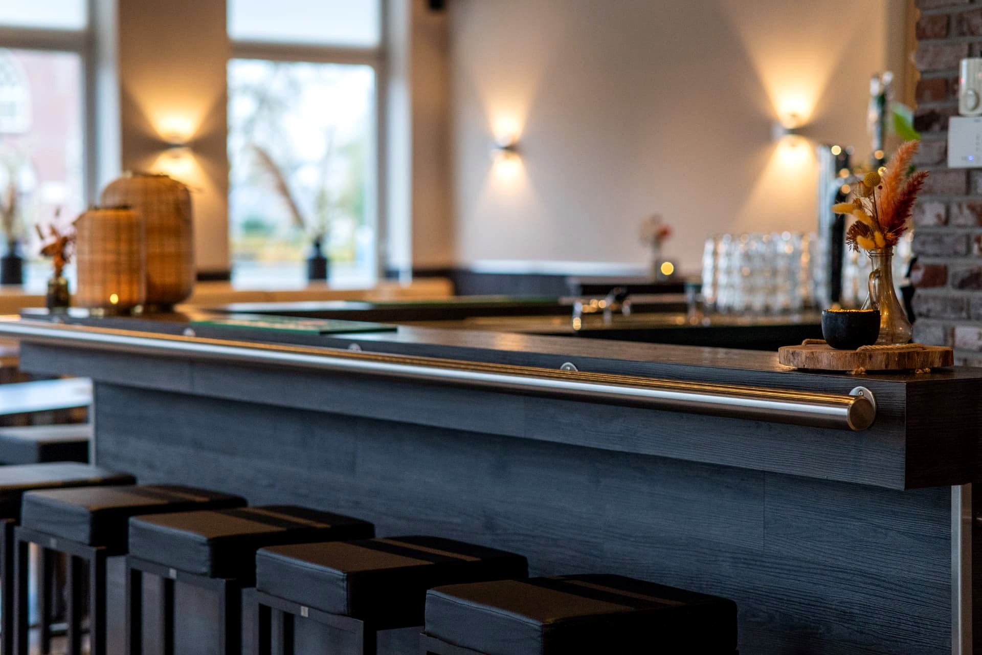 Lange bar met barkrukken en wandverlichting in zalencentrum D' Olde Skoele Rouveen