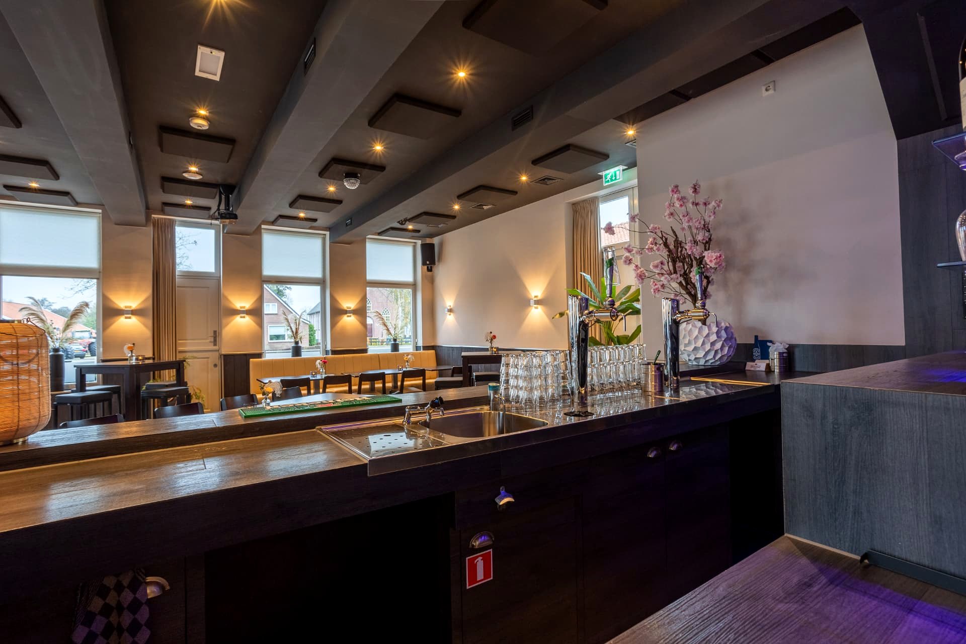 Bar met tapinstallatie en zithoek met bank in de borrelzaal van D' Olde Skoele Rouveen